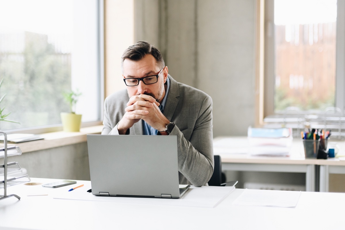 Businessman working on laptop computer in office.