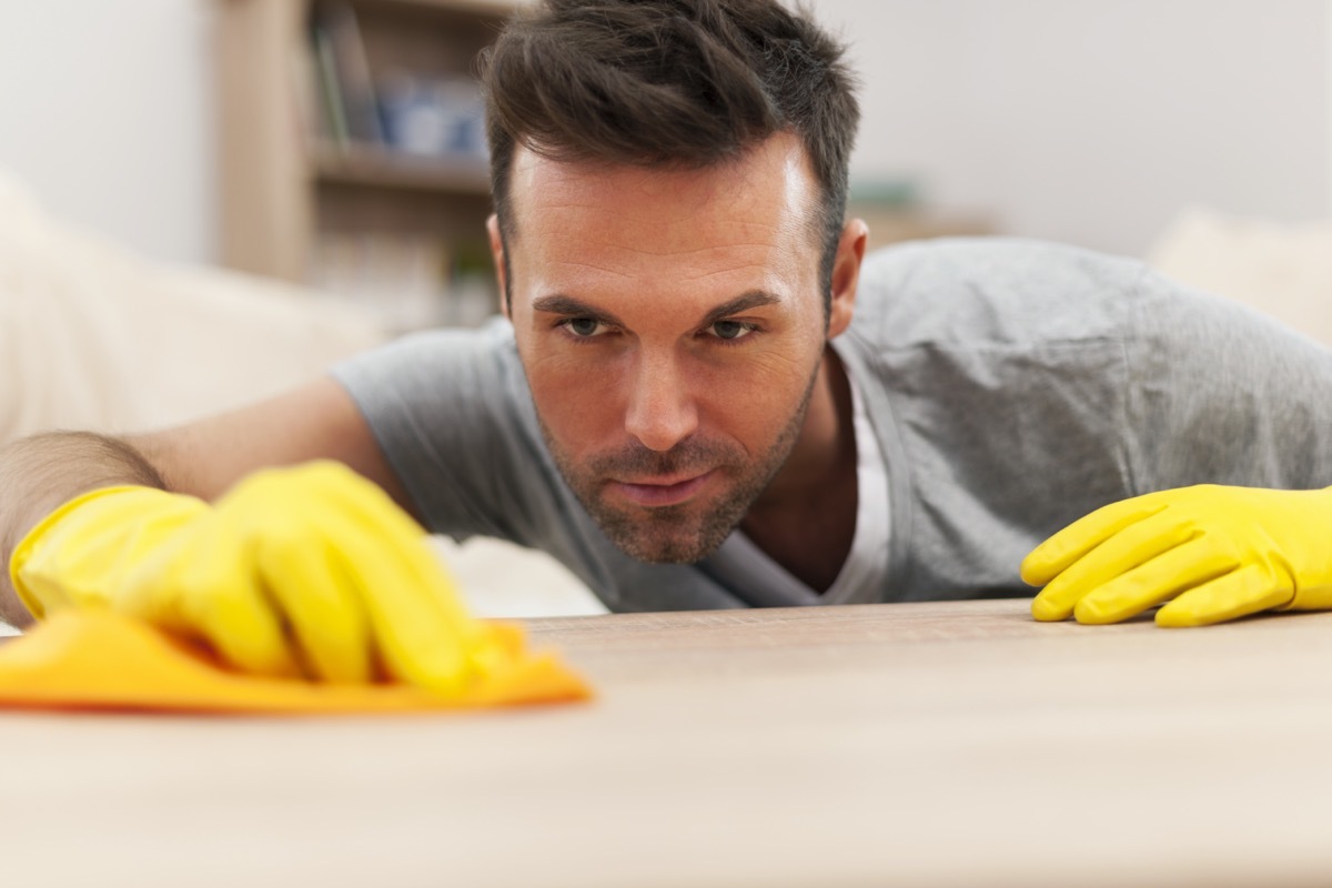 man cleaning stains off the table