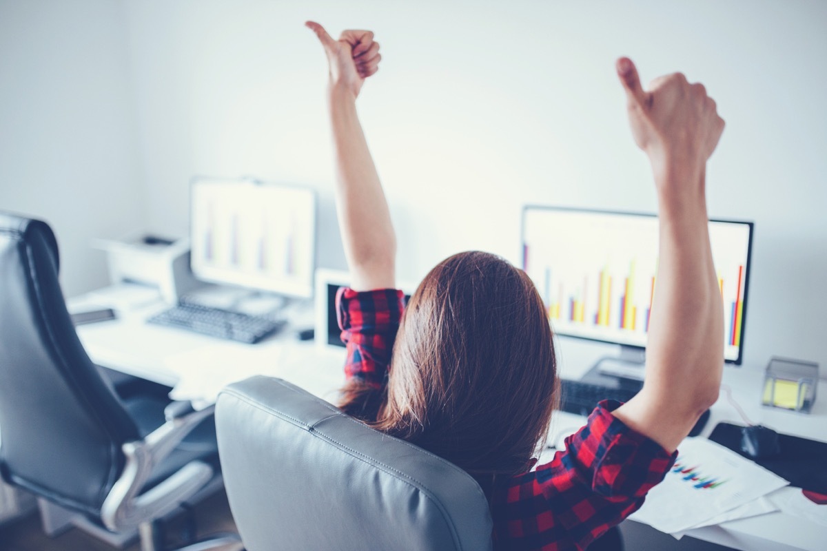 woman sitting at her computer giving two thumbs up