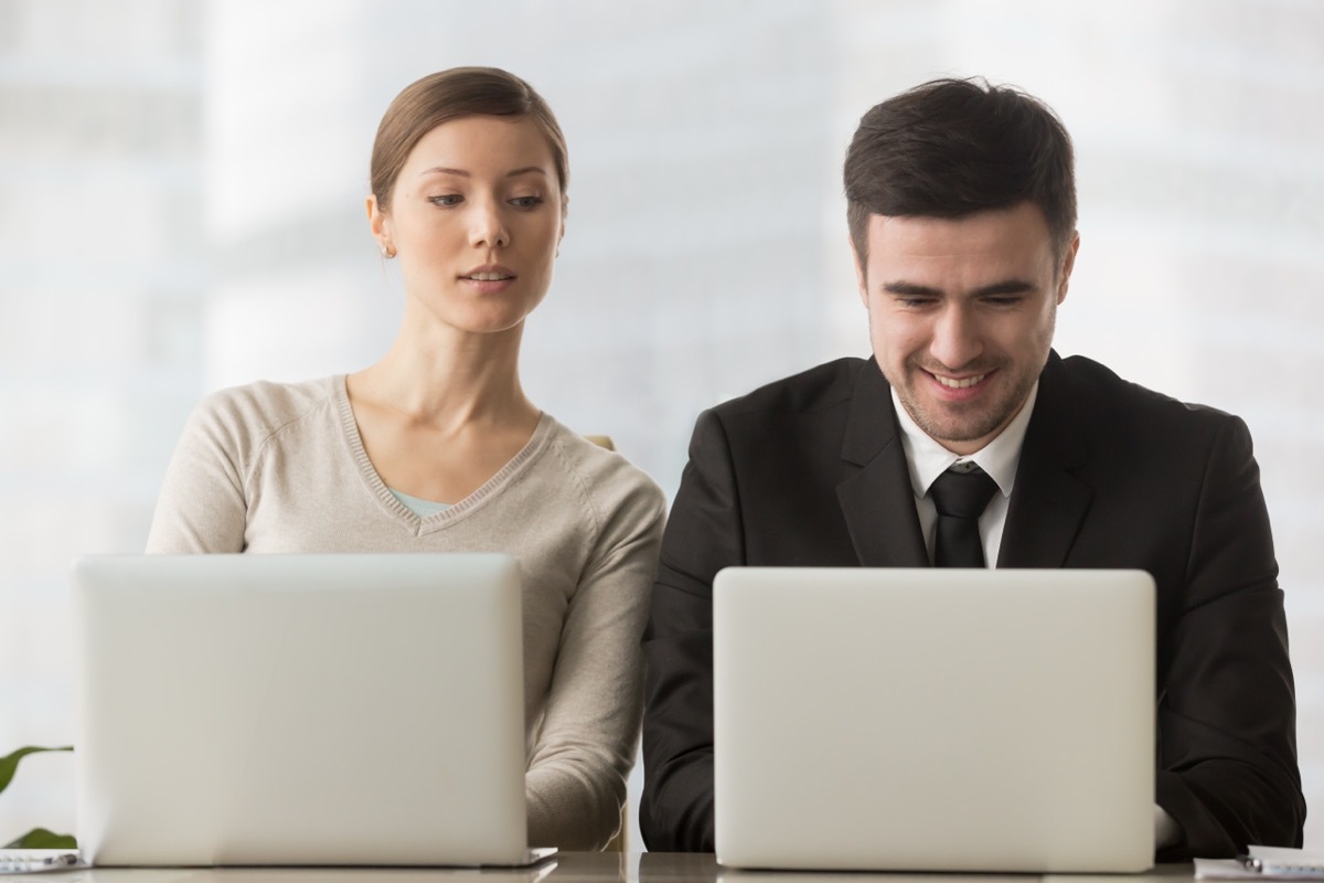 Woman Looking Over Man's Shoulder