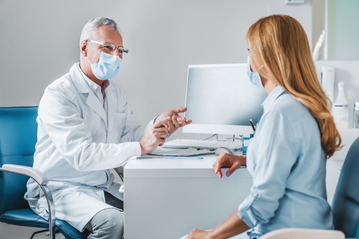 Male doctor speaks to woman patient