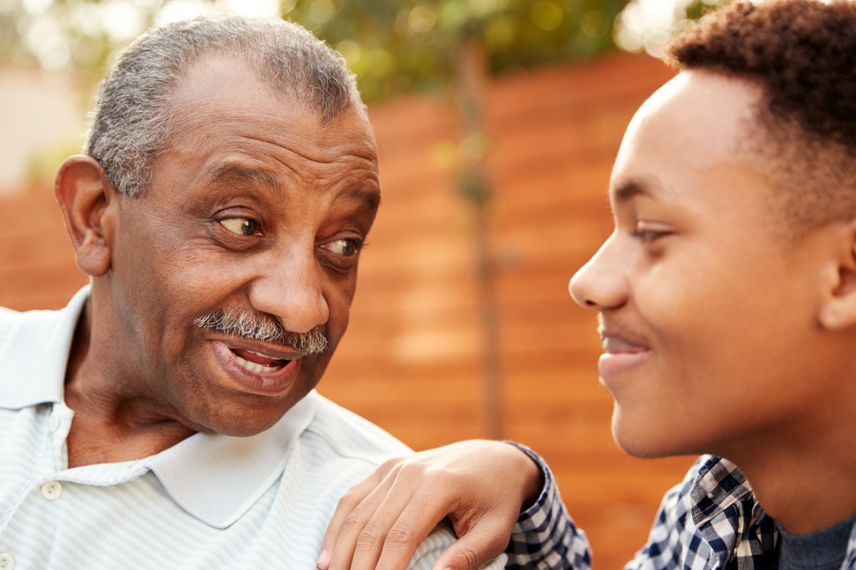 black grandfather talking to teenage grandson