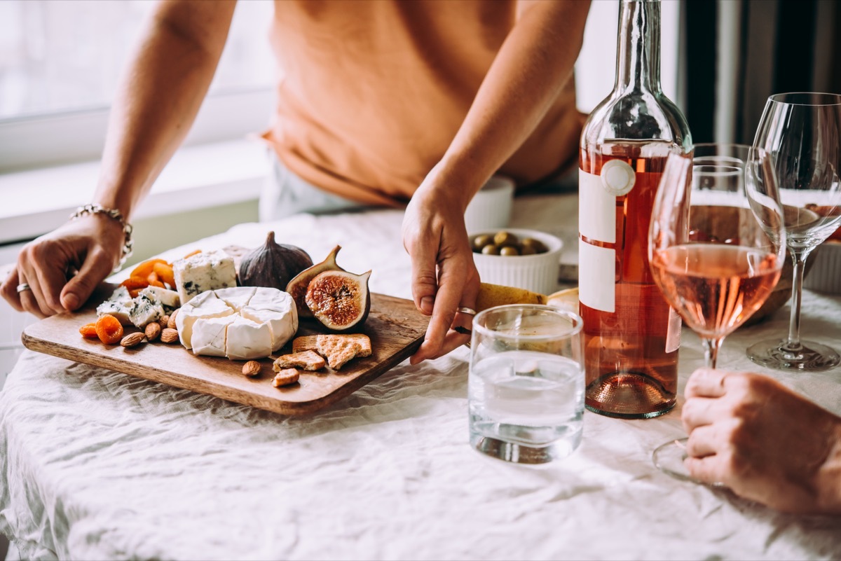 friends sharing some wine, fruit, and cheese at a dinner party