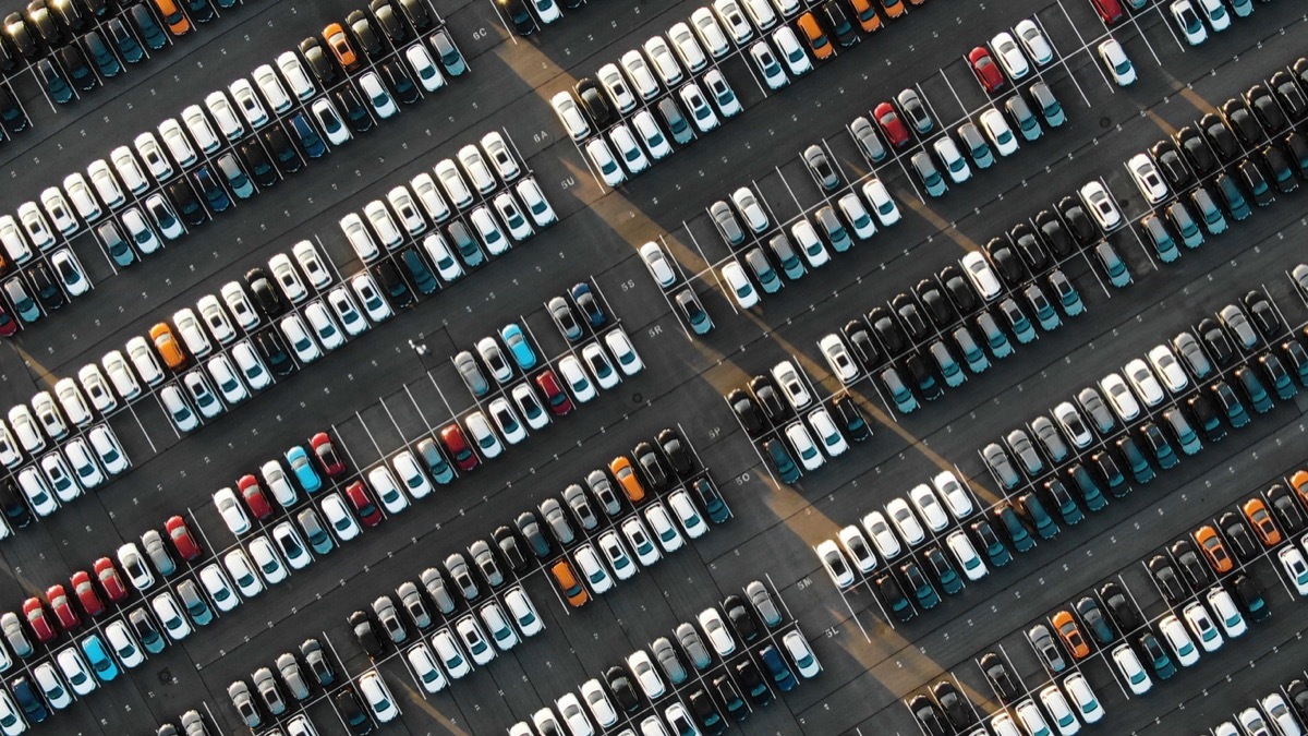 dozens of cars parked, for sale in a parking lot