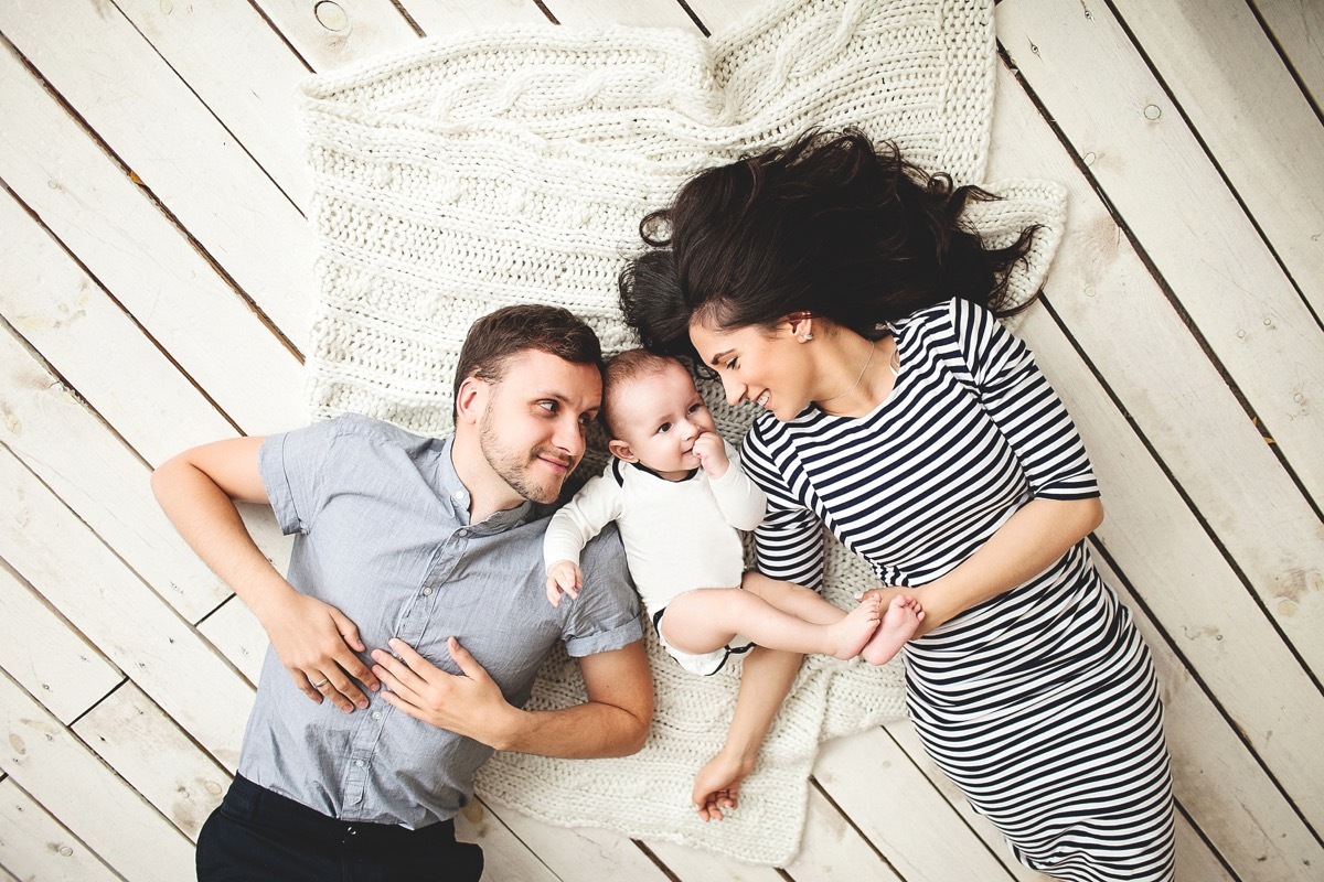 happy family laying on wooden floor