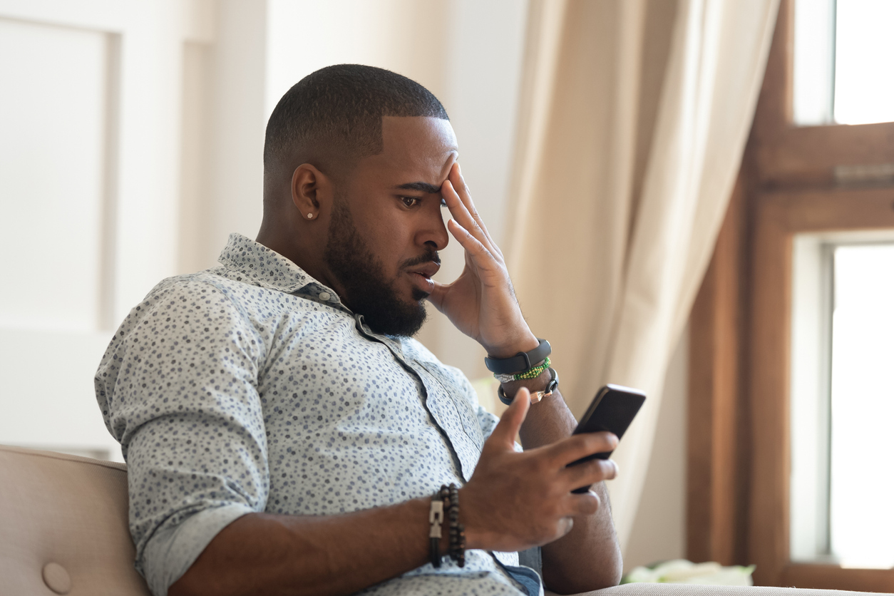 Distressed man looking at his phone.