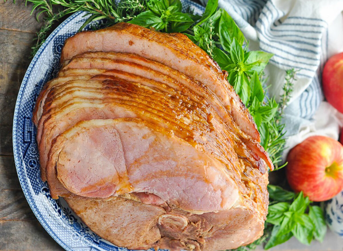 crock pot glazed sliced spiral ham on serving platter with apples