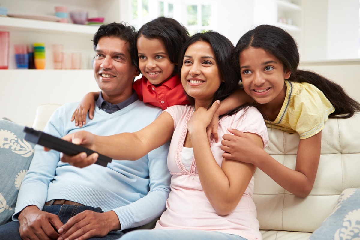 indian family watching tv on couch