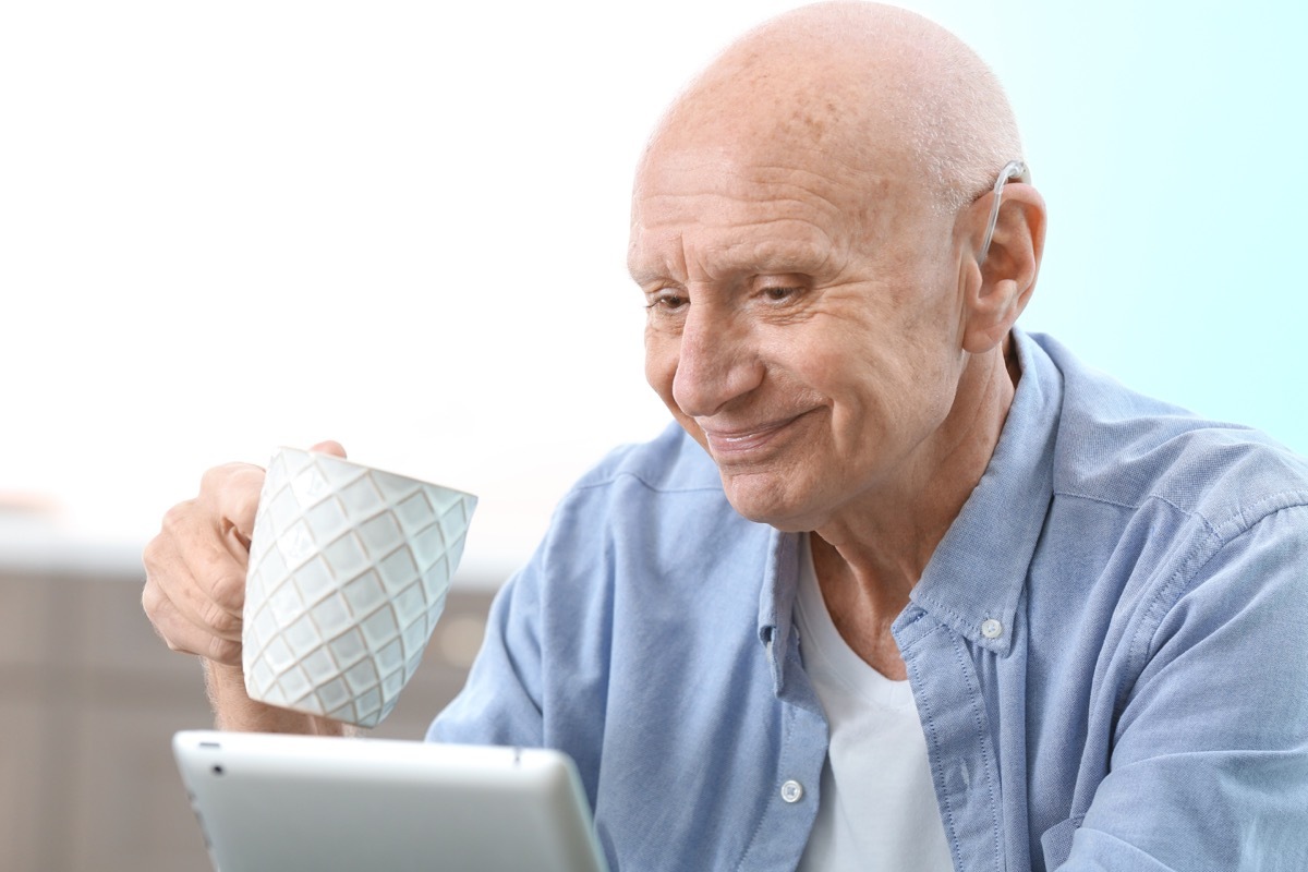 Man wearing hearing aid while on computer