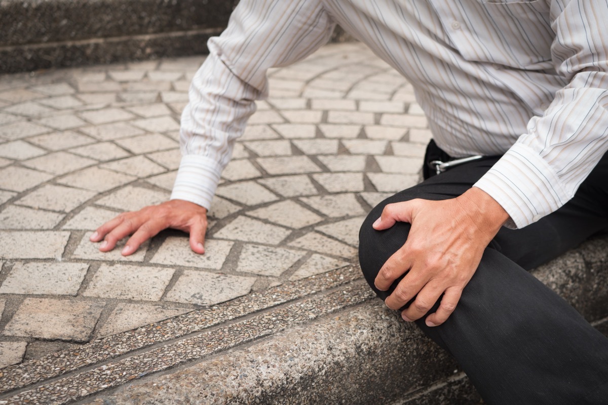 man tripping up and falling over himself in public