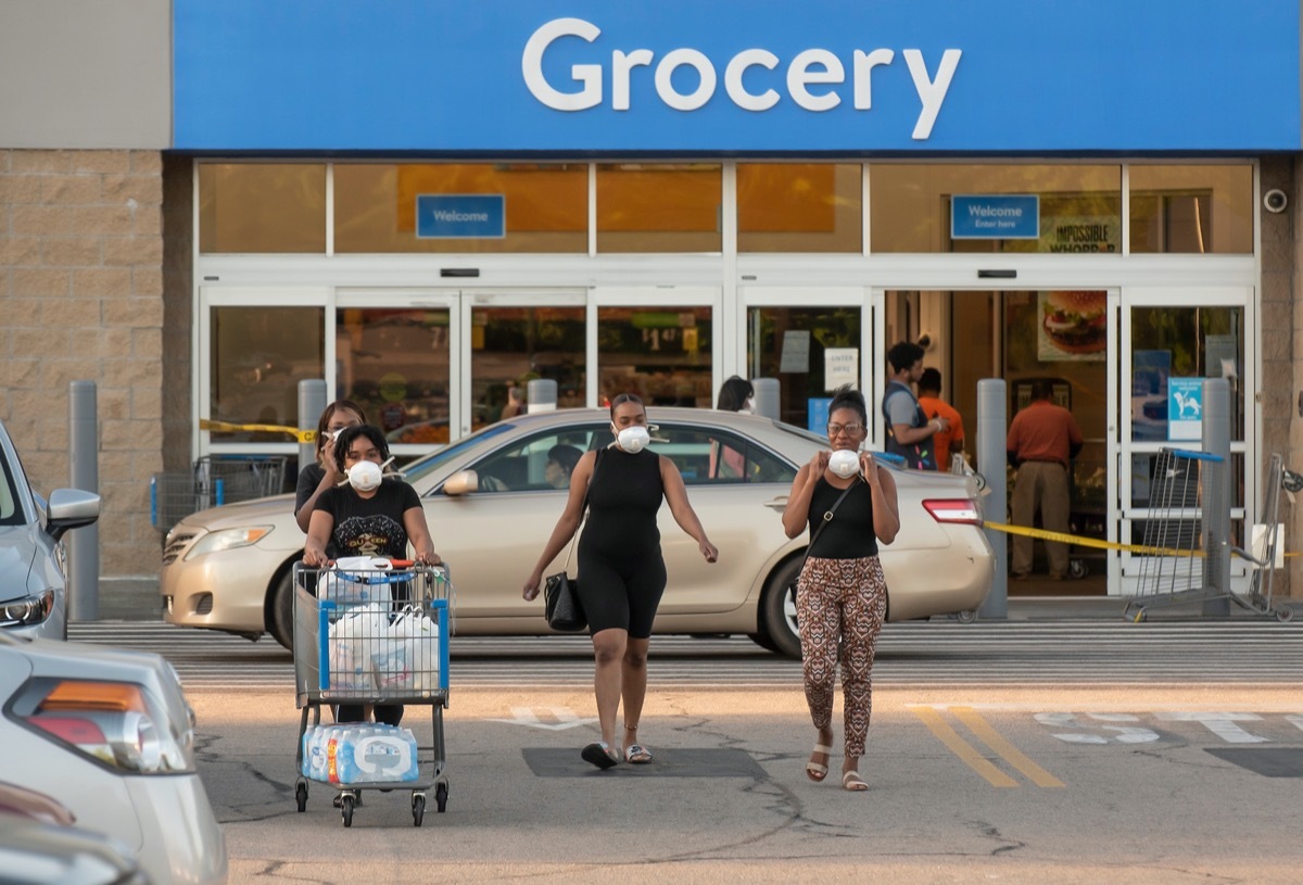 A group of African American ladies wearing protective face masks exit a Wal-Mart amid the COVID-19 epidemic