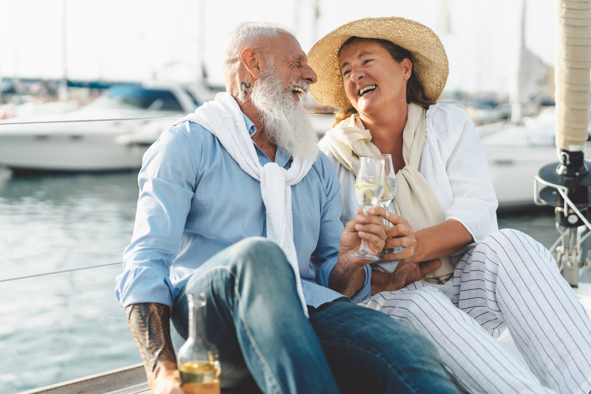 Senior couple toasting champagne on sailboat vacation