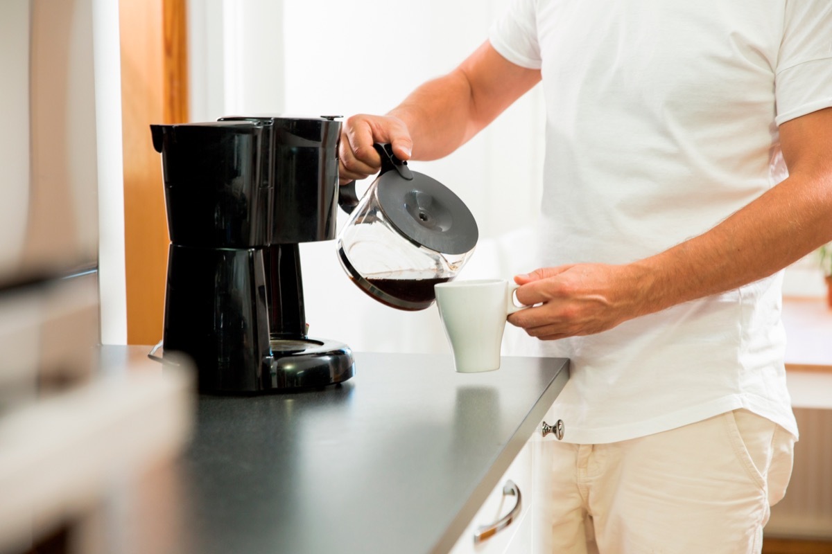 Man pouring coffee into mug