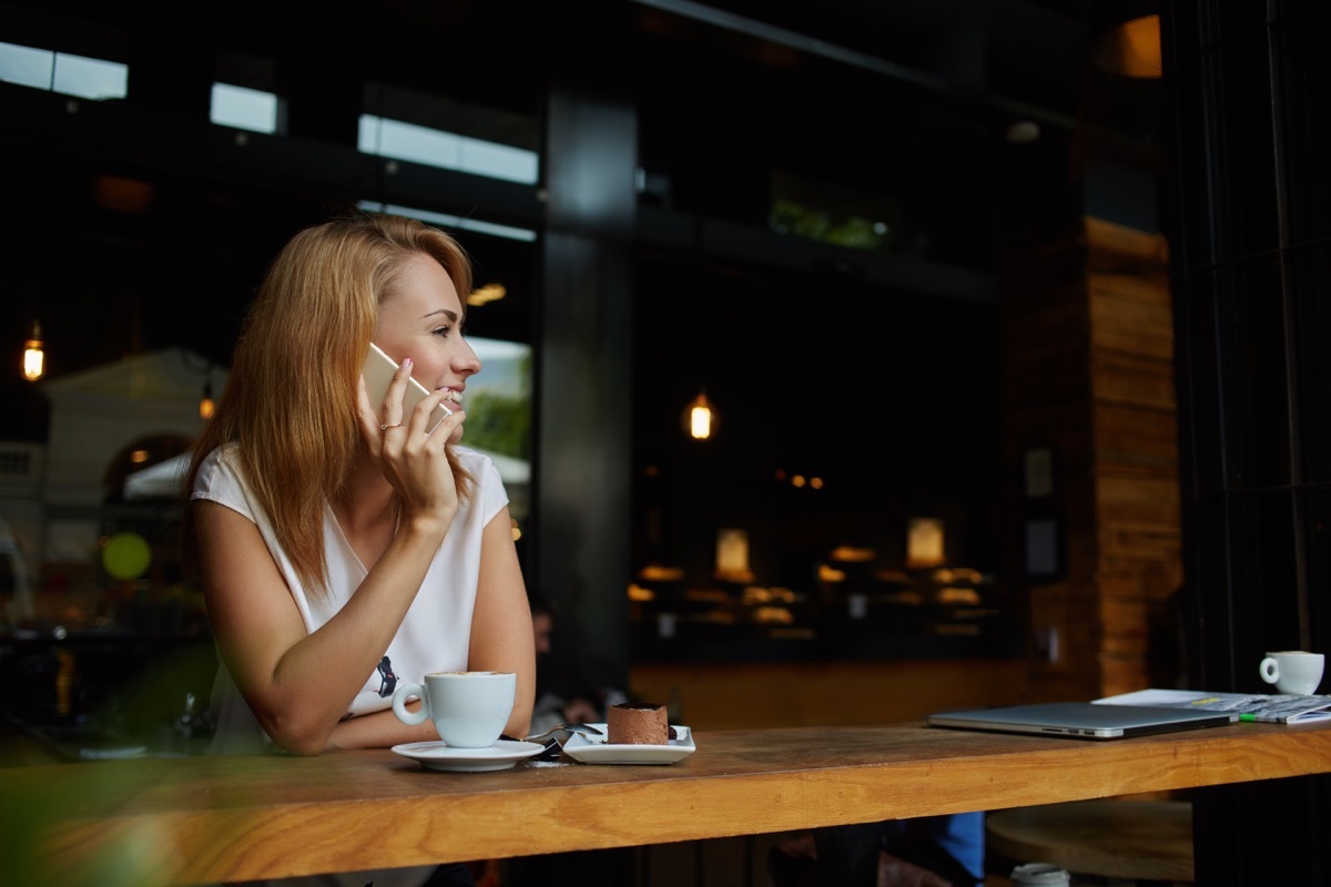 Woman on a call in a coffee shop at night