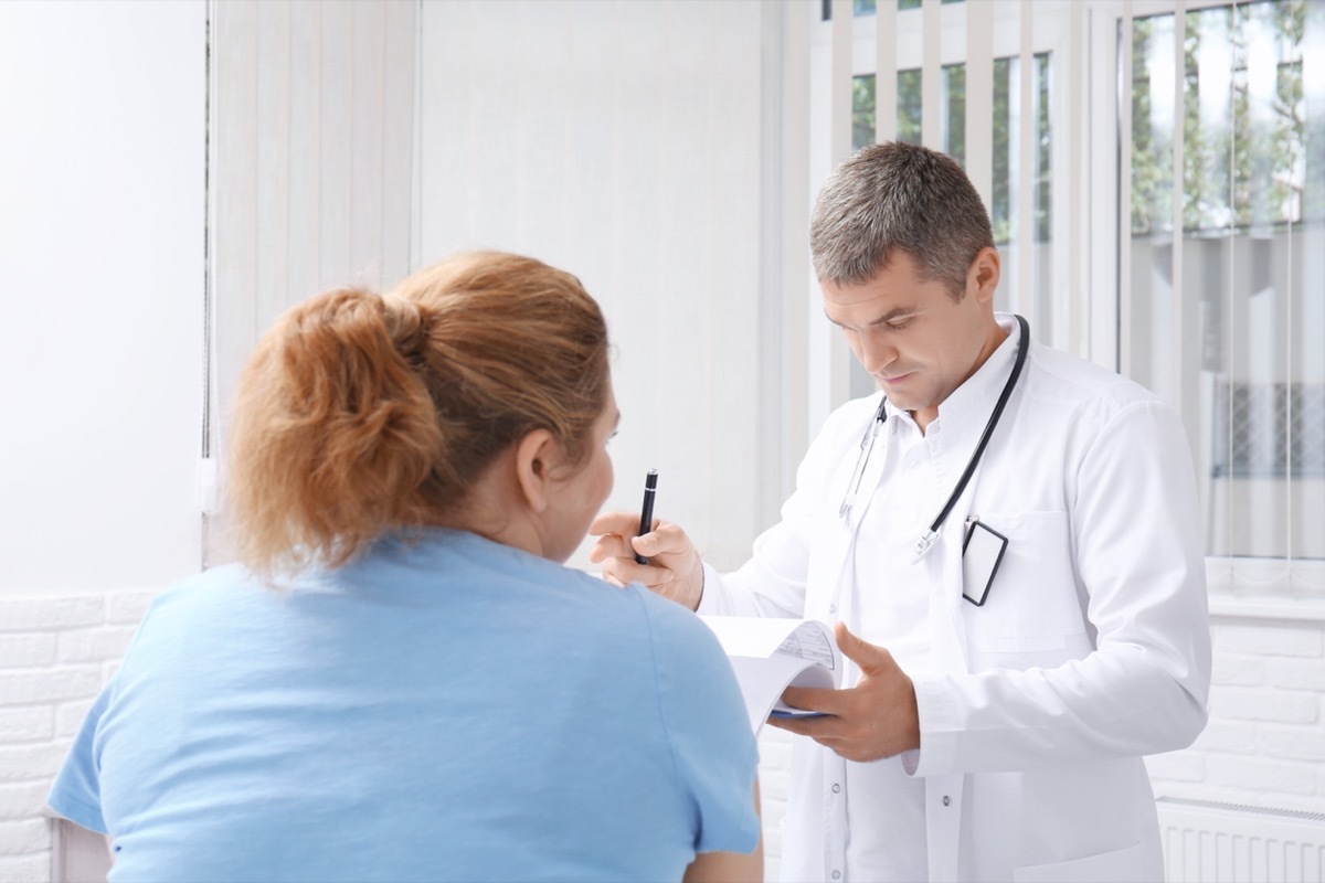 Overweight woman discussing test results with doctor in hospital