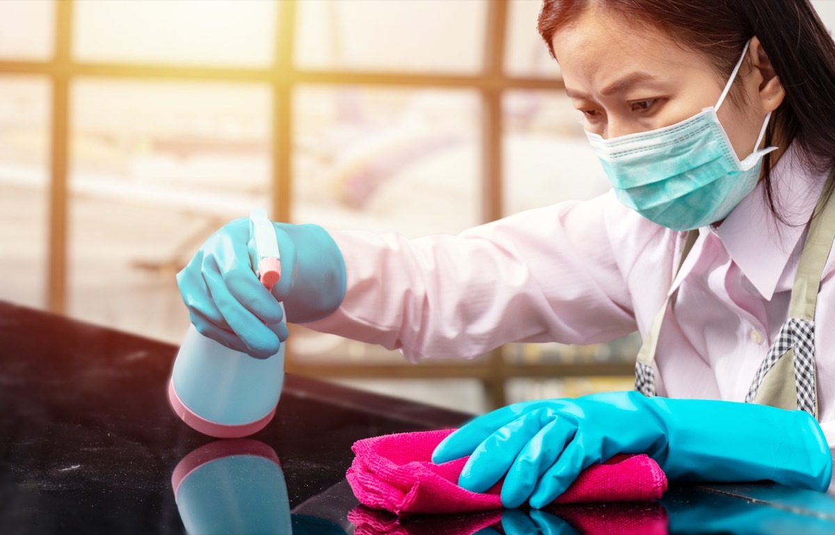 Woman spraying disinfectant with towel