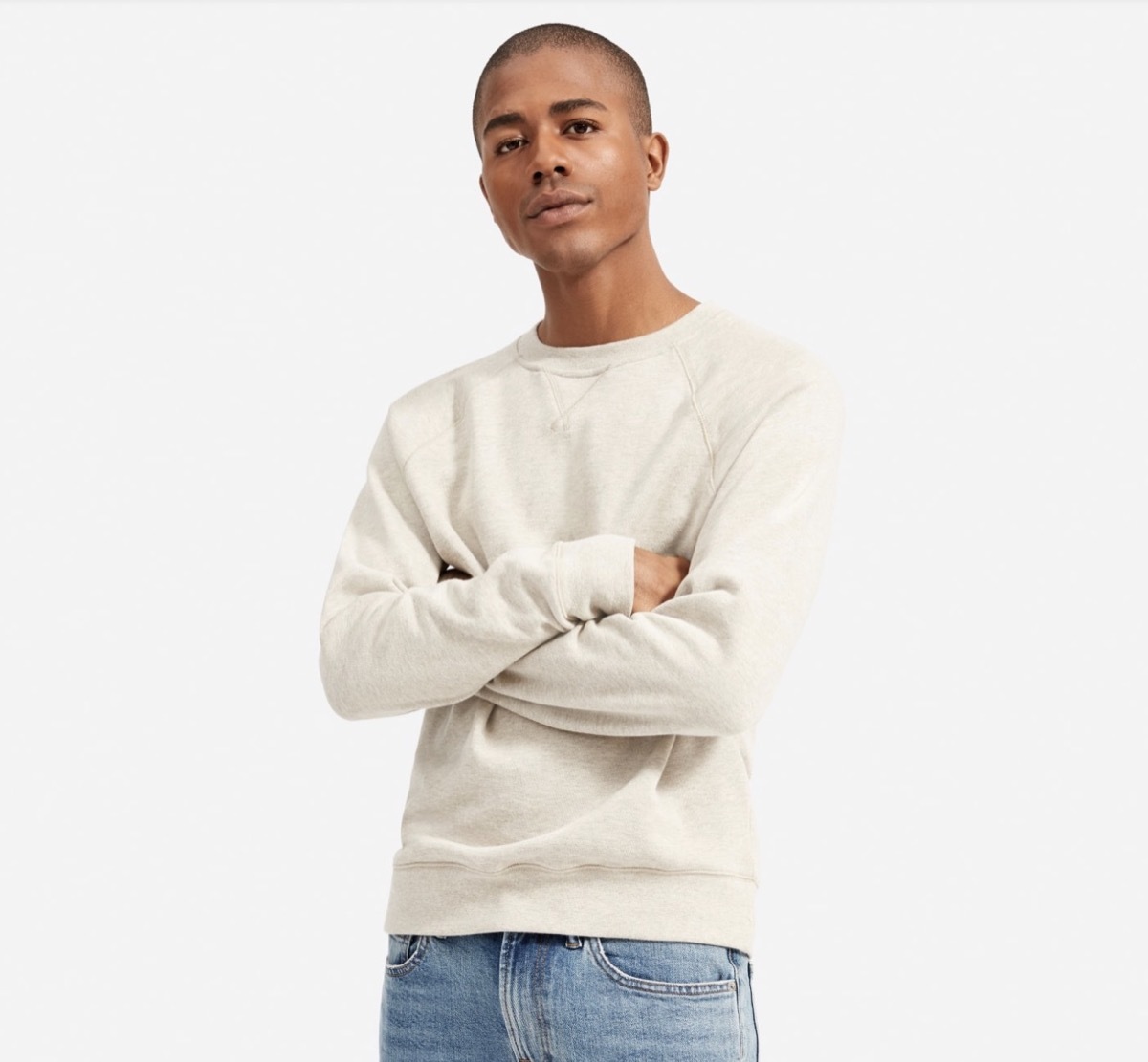 young black man in cream colored sweatshirt