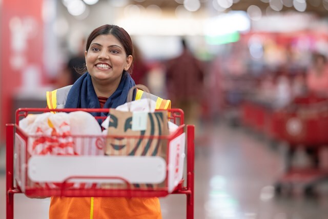 A Target employee wheeling a cart with a customer's drive-up order.