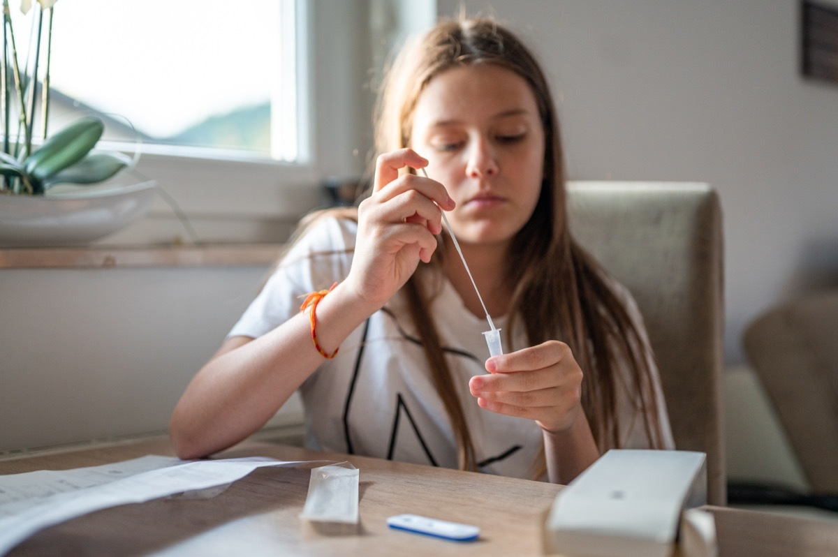 Young school girl doing a Covid self-test at home.