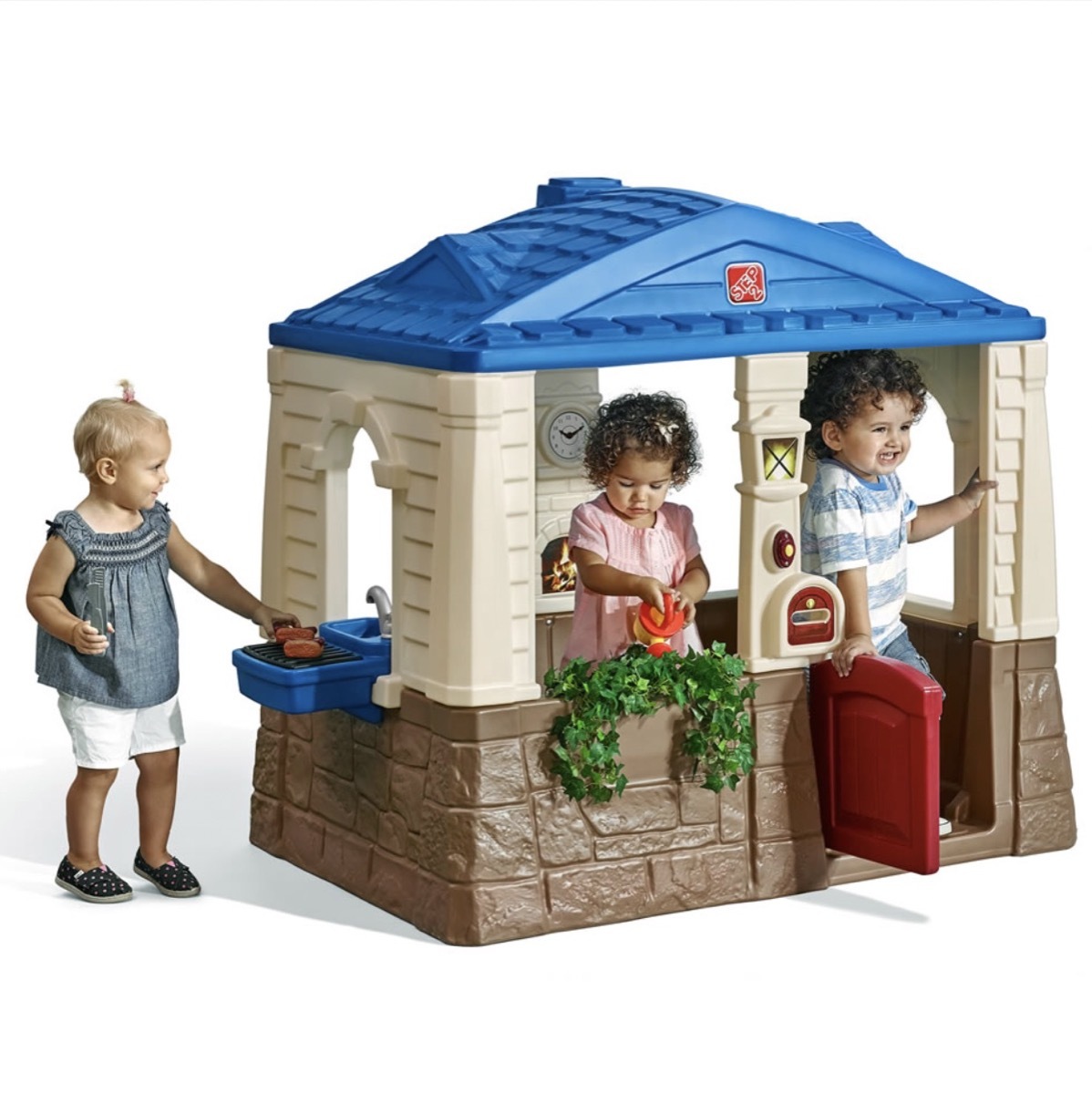 three children playing in a plastic outdoor playhouse