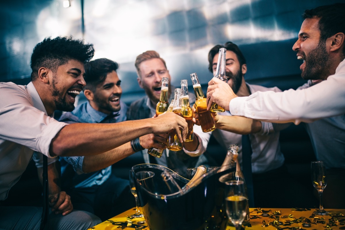 men toasting at a nightclub, drinking beer