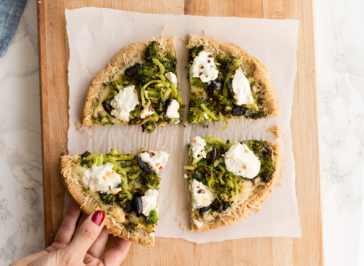 spiralized broccoli and olive bianca white pizza on wax paper ready to serve