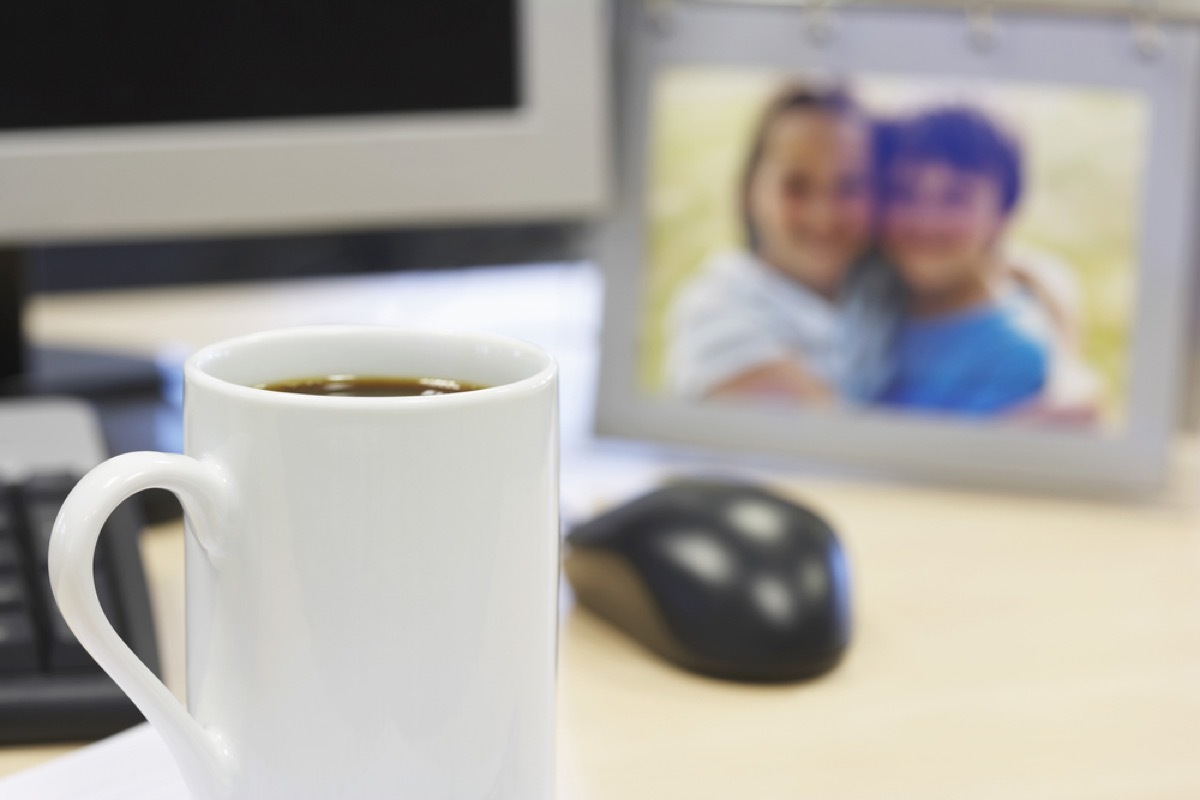 desk with mouse, coffee mug, and family photo, office etiquette