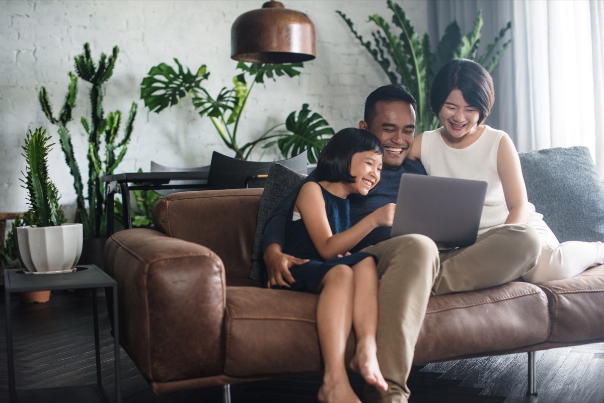 Family looking at laptop on couch together