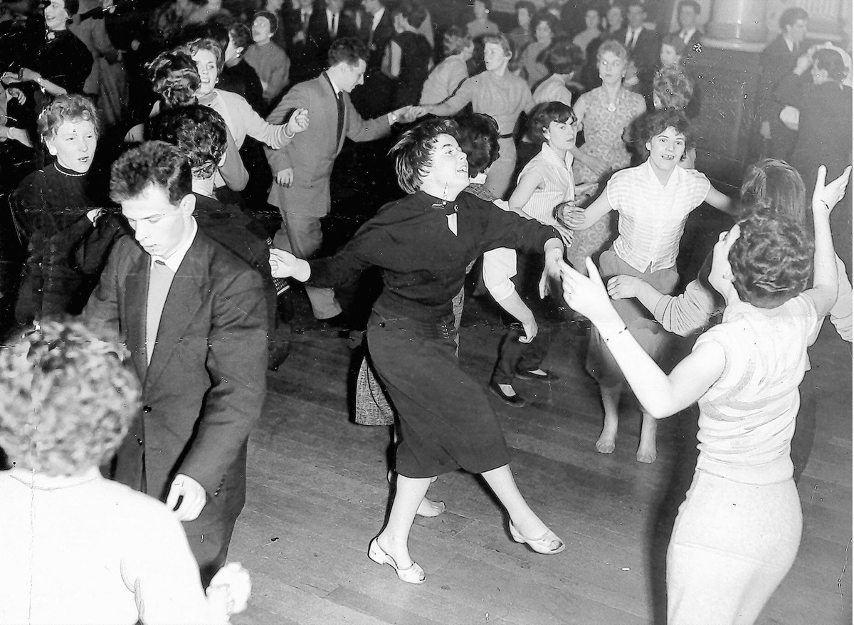 1950s young dancers crowd the floor for a rock n roll dance, cool grandparents