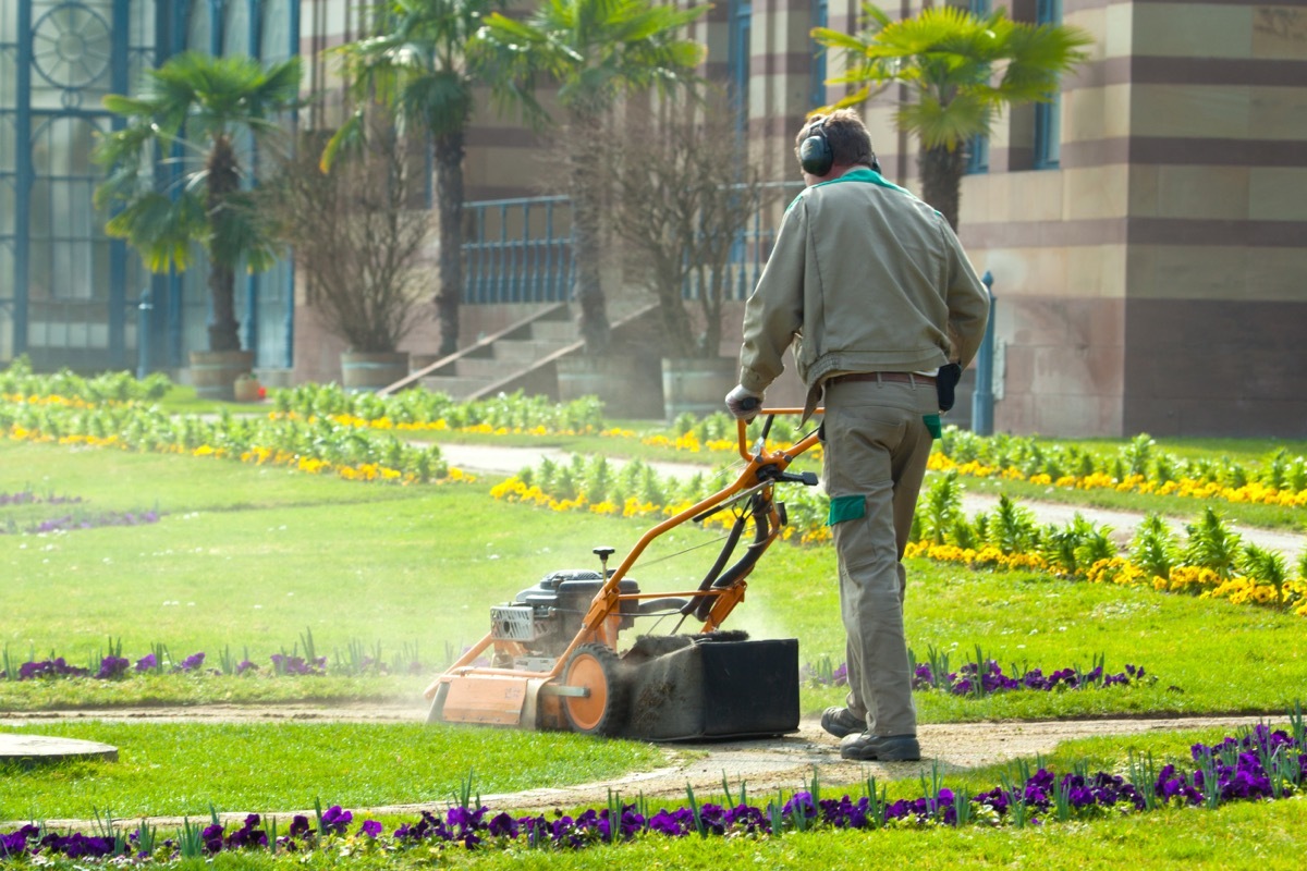 grounds maintenance worker mowing lawn