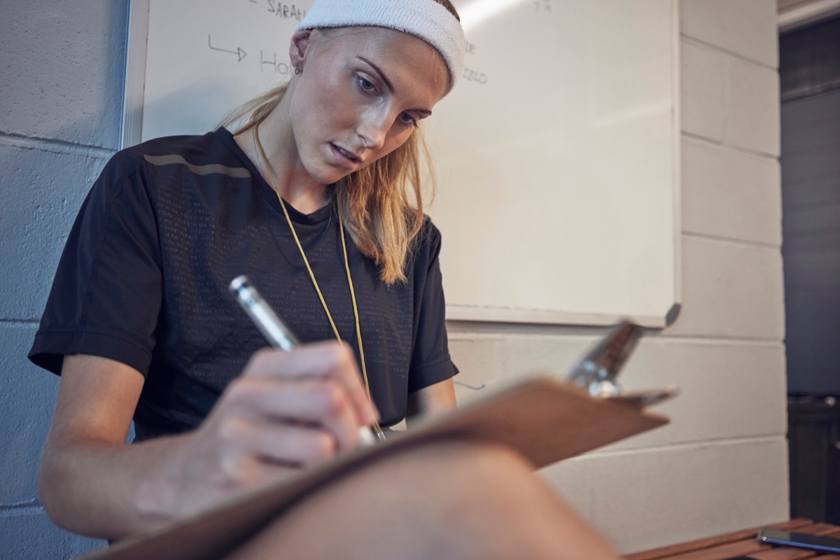 Woman Writing Notes on Clipboard