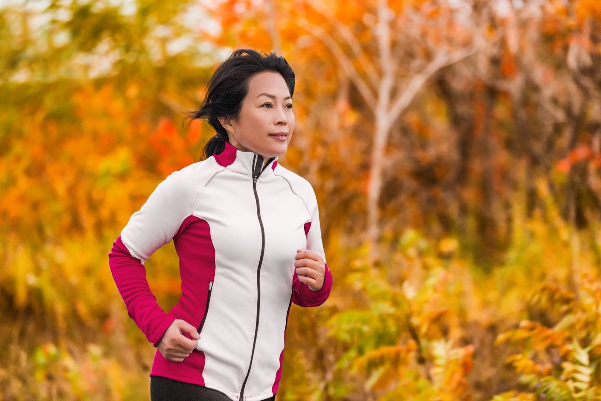 asian woman running in woods