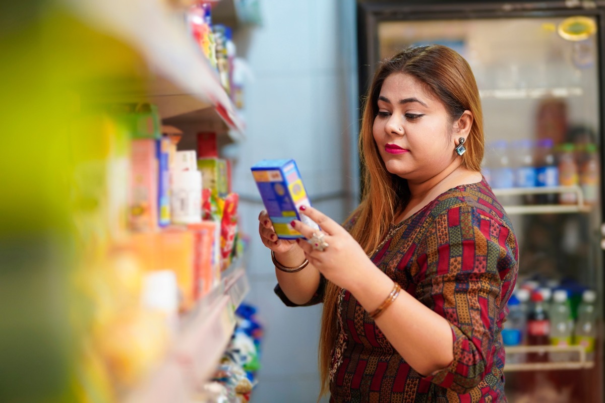 woman checking price at grocery store