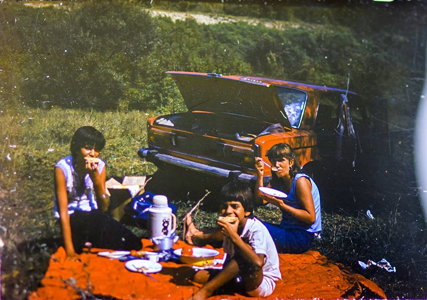 two women and a boy have a picnic in the park