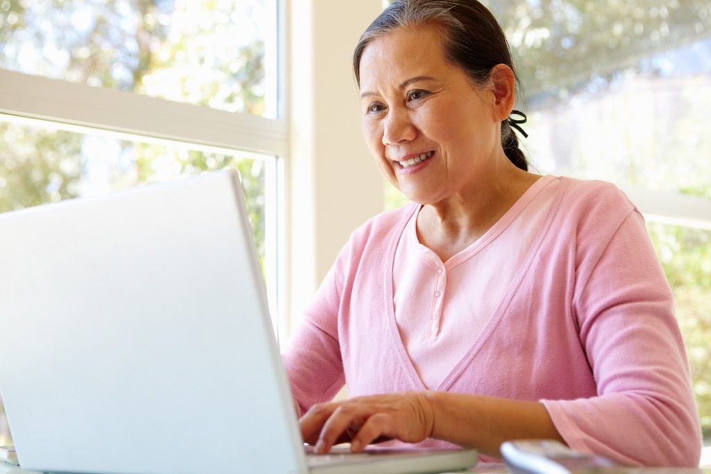 older woman on computer, sitting all day is bad for your heart