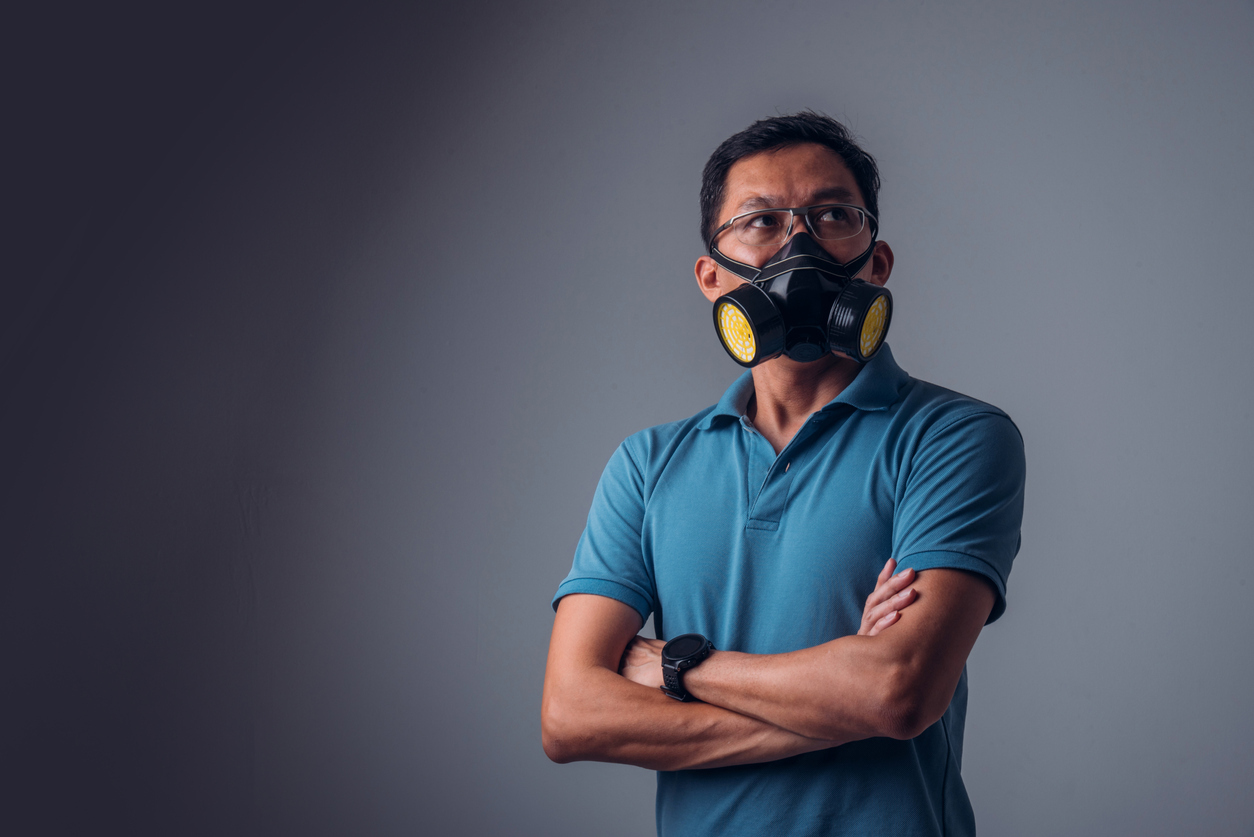 asian man in a blue collared shirt wearing an elastomeric mask