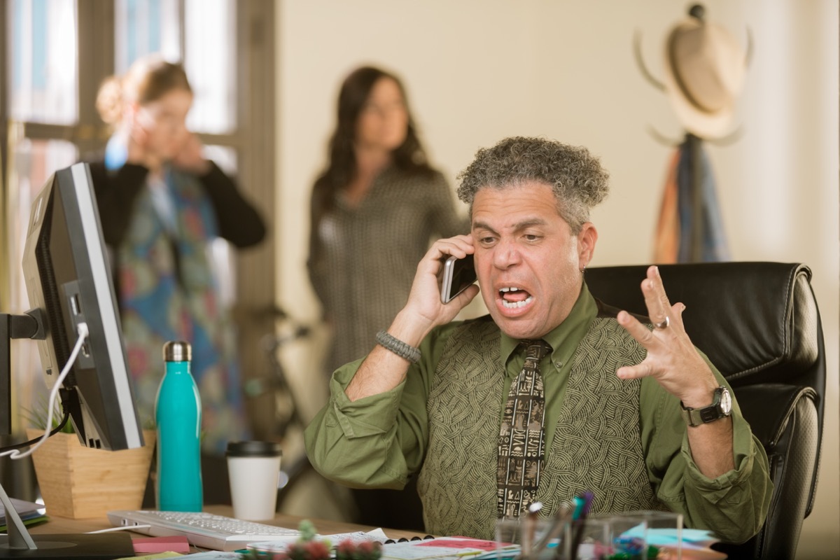 Man of color sits at desk screaming at phone, hings not to say to customer service rep