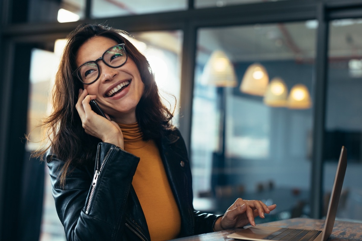 happy asian woman chatting on the phone