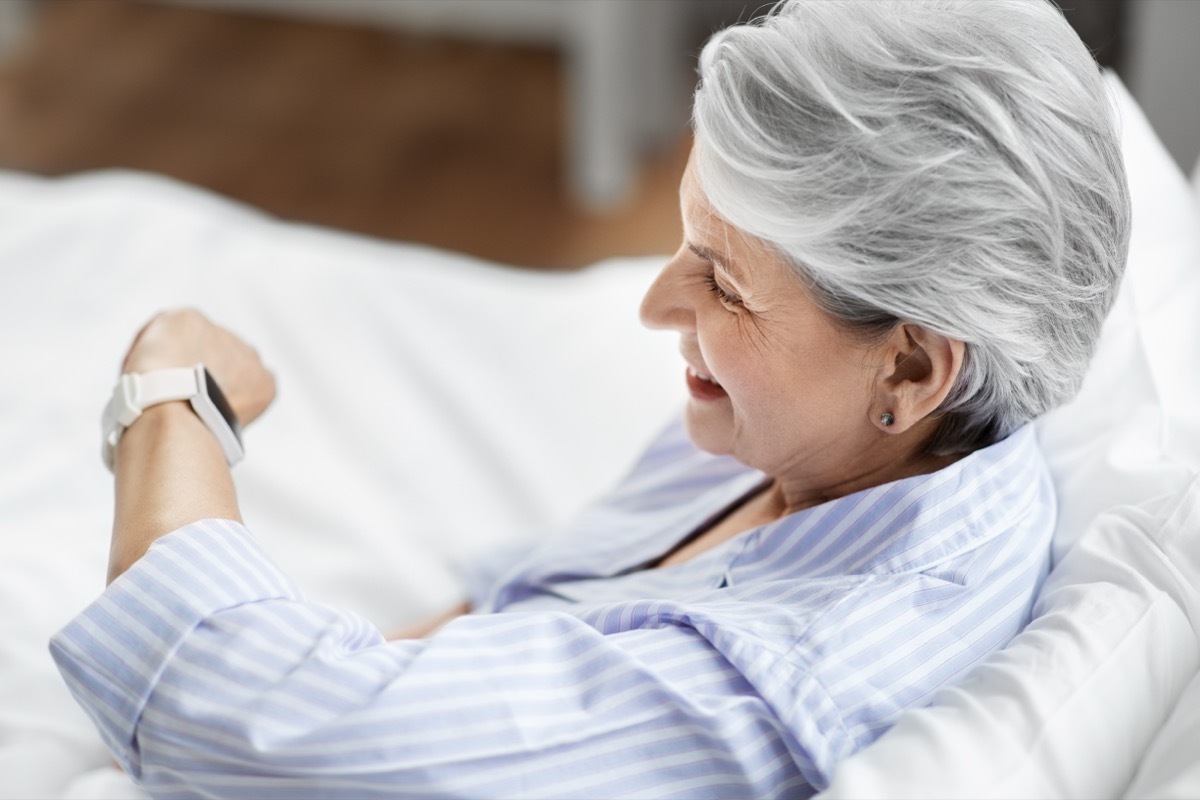 older woman looking at watch in the morning