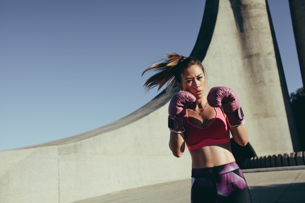 Woman kickboxing ways to de-stress