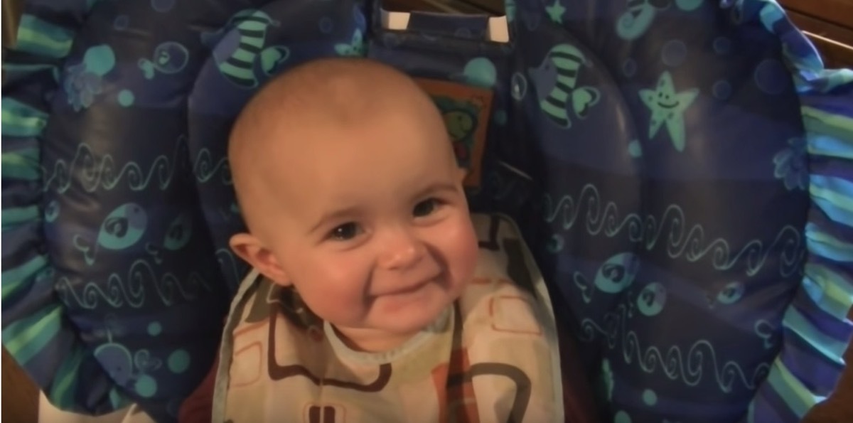 smiling white baby in blue high chair