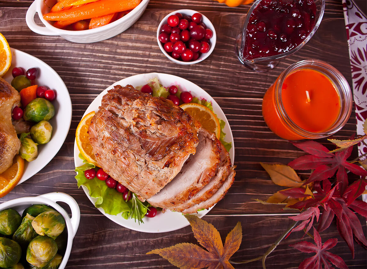 glazed ham as part of holiday spread with side dishes and candle