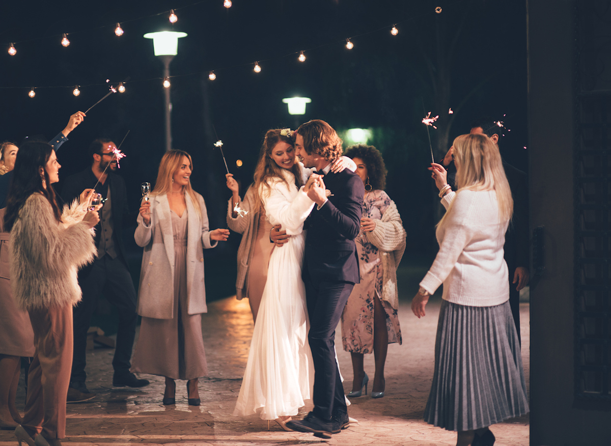 Happy newlywed couple dancing and celebrating at wedding party with friends and family