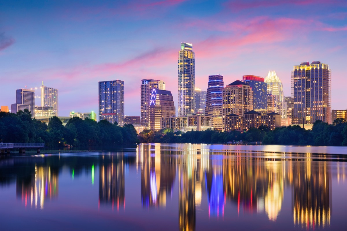 city skyline on the Colorado River in Austin, Texas at dusk