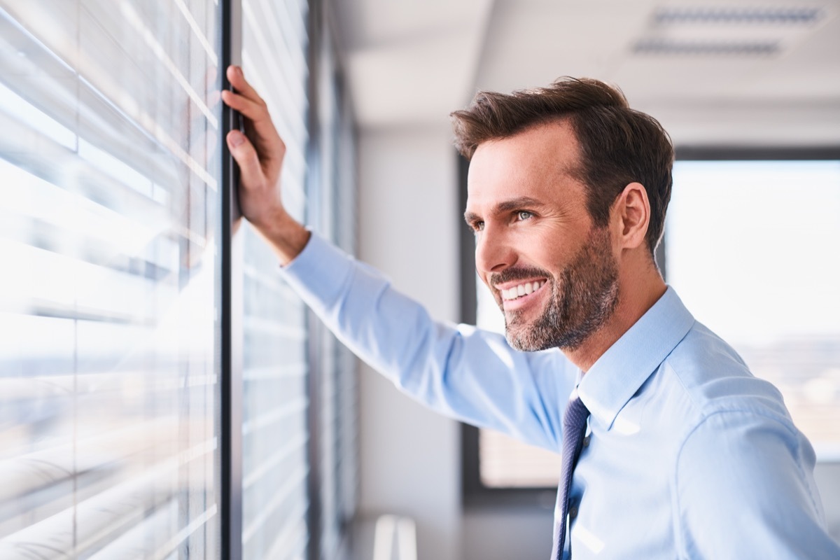 Happy man looking out of window happier life in 2019