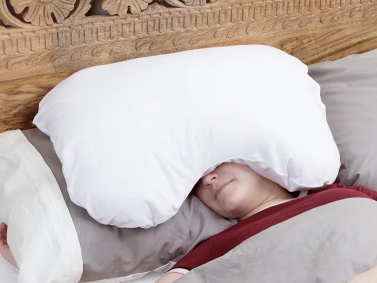 woman with white pillow on her head, better sleep essentials