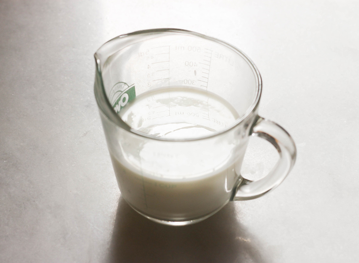 Cup of homemade buttermilk on a marble counter