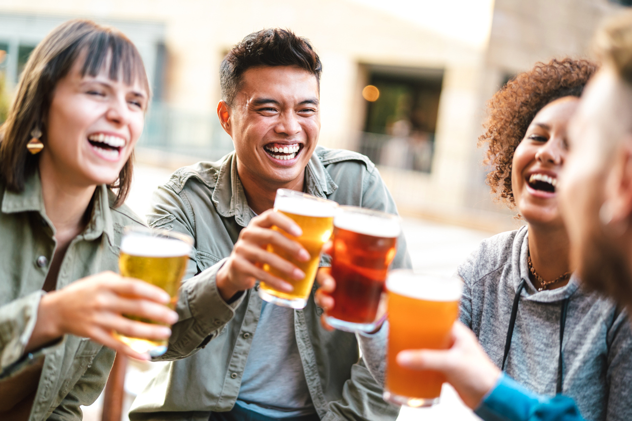 A group of friends drinking beer outdoors at a brewery