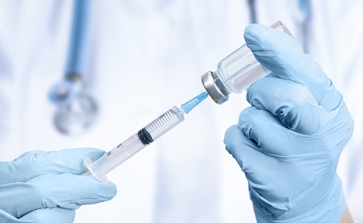 the doctor holds a vaccine and a syringe in his hands. close-up. vaccination of diseases