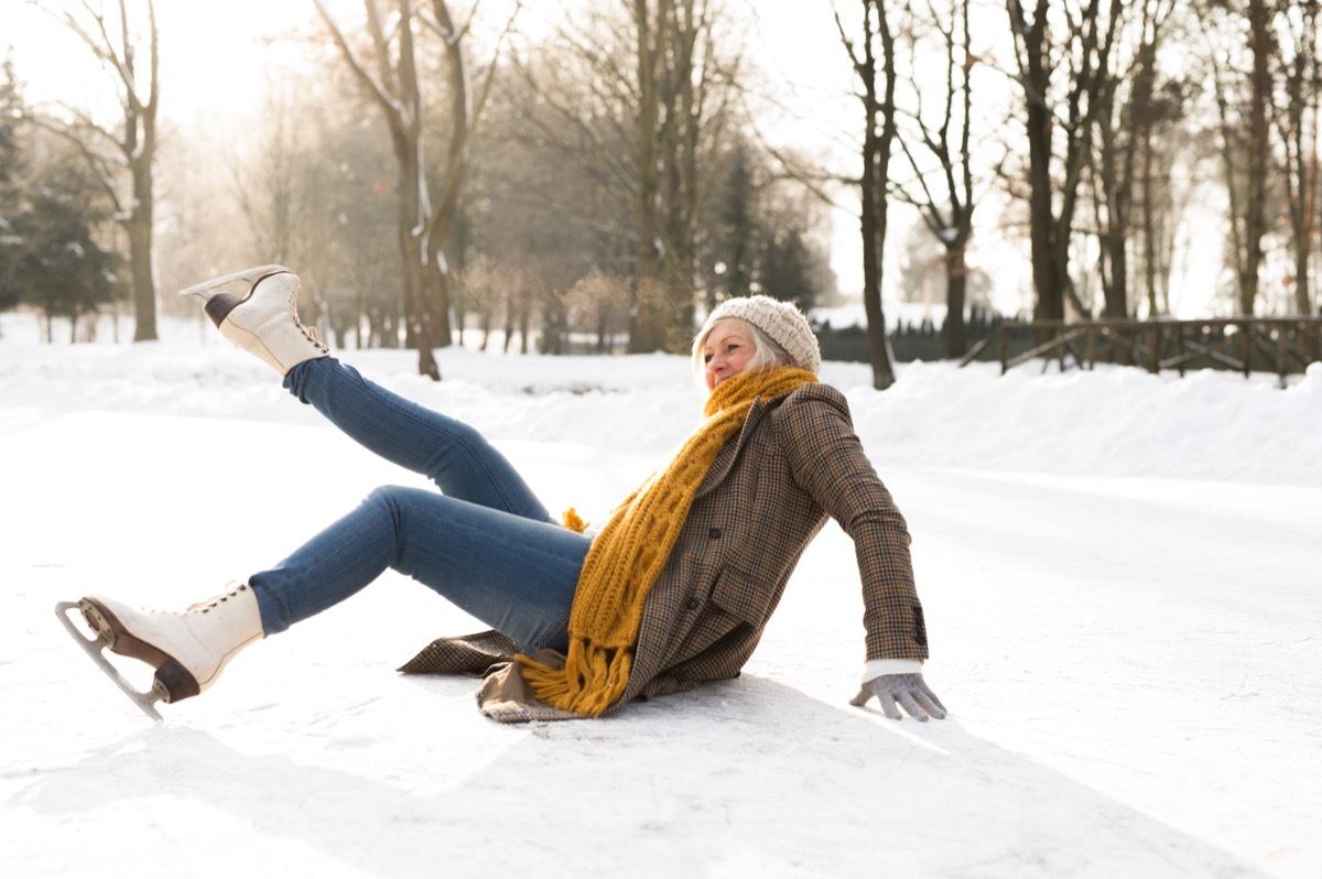 Woman falling on ice while ice skating